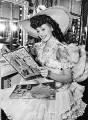looking at Rita Hayworth coloring books and paper dolls during filming of My Gal Sal